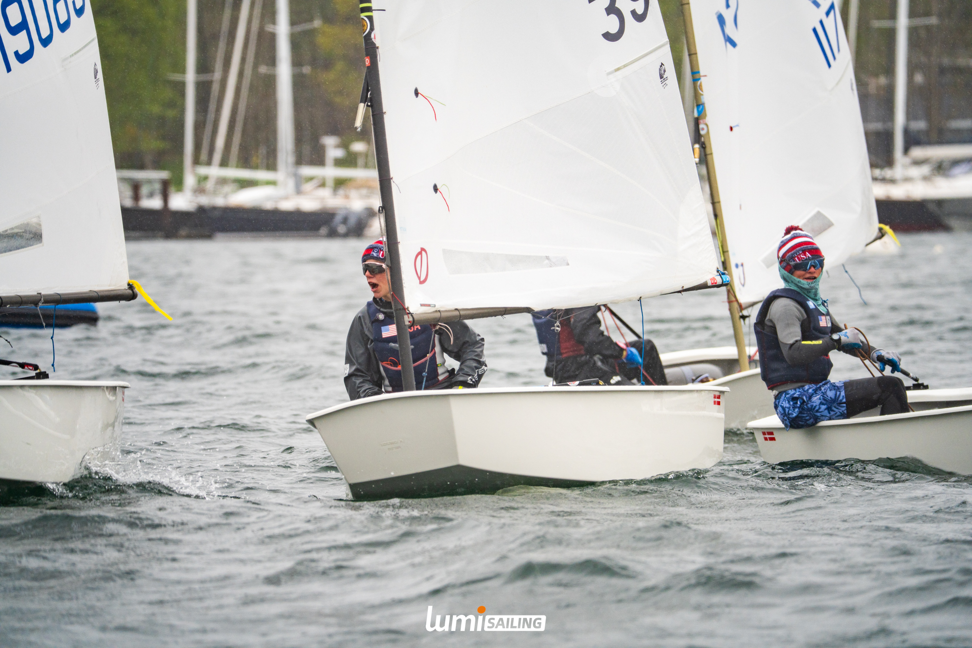 Optimist sailors racing in cold wet conditions
